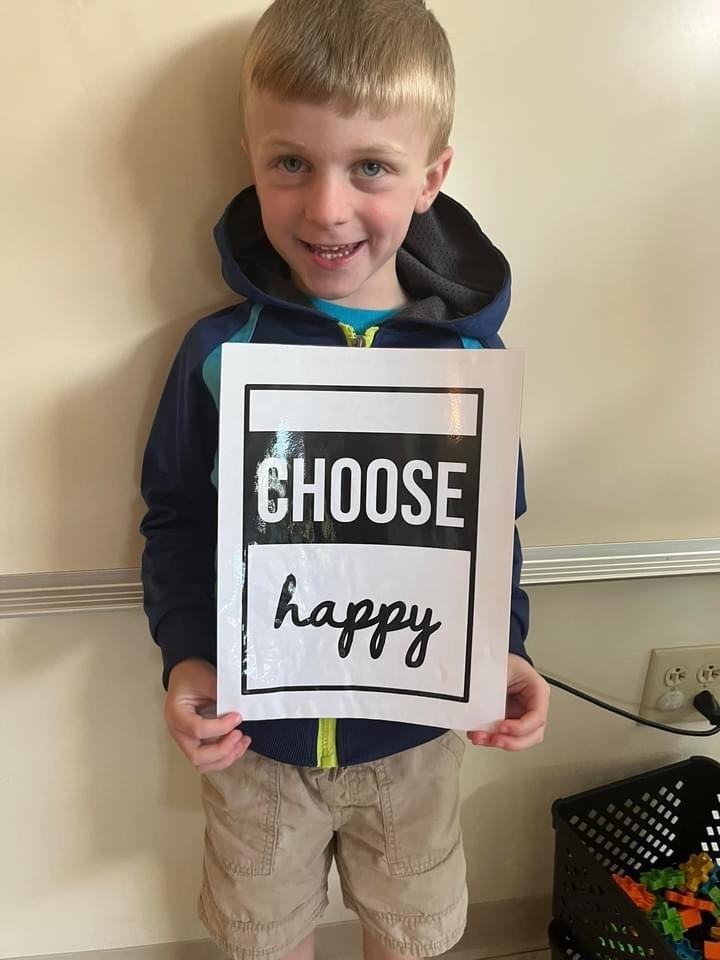 kindergarten student with choose happy sign