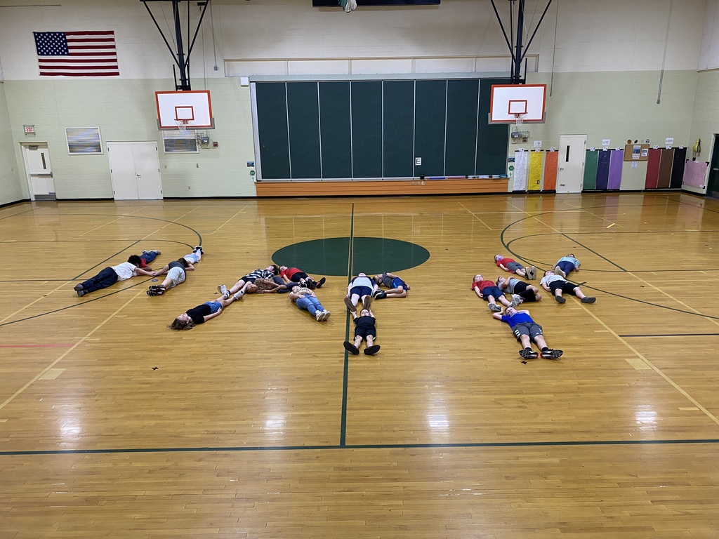 5th grade class spelling out happy on gym floor