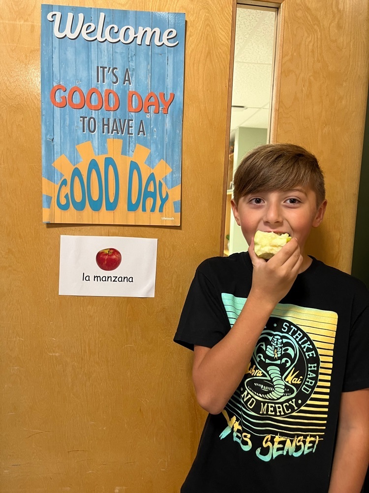 Student eating an apple by la manzana sign