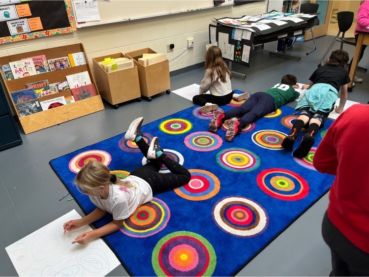4 students students kinetic drawing on a rug