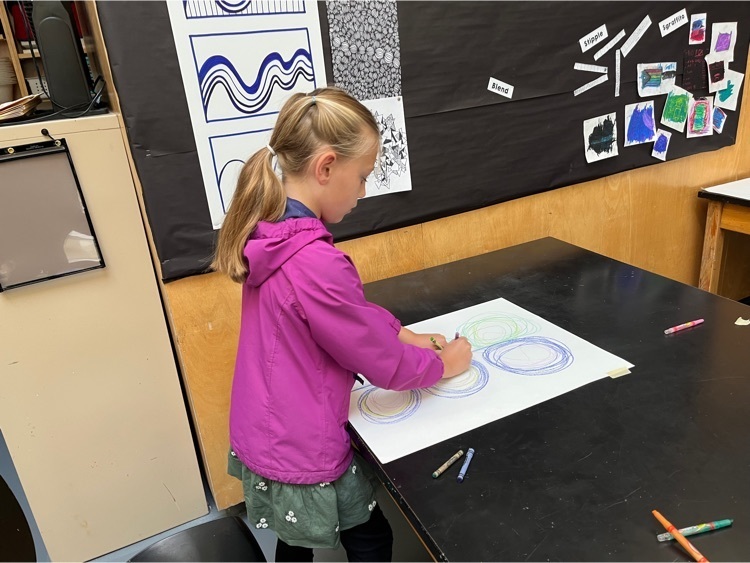 students kinetic drawing at a table