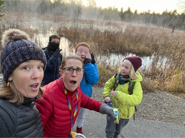 group of students and staff standing in front of a foggy swamp