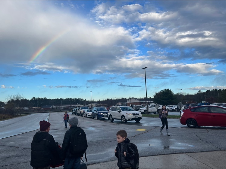 students walking into school with a rainbow overhead