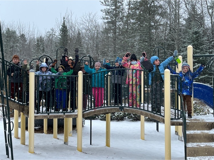 students celebrating the first snow on the playground structure