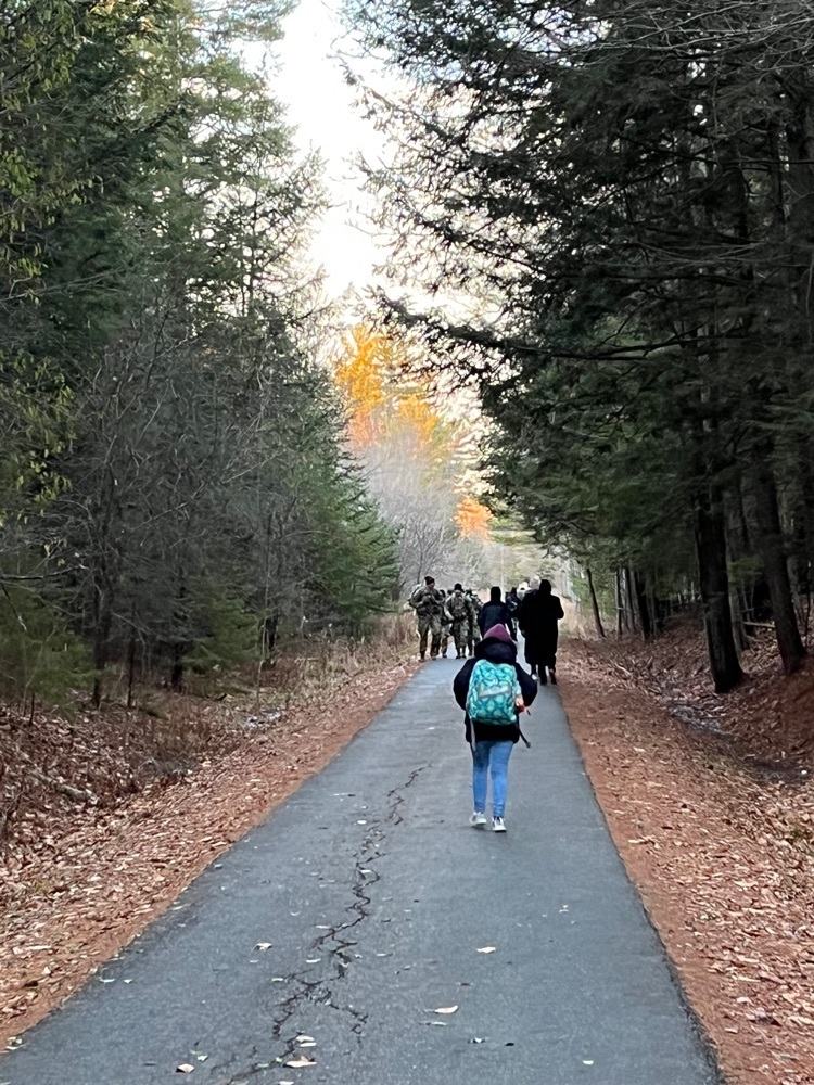 students and staff walking on a tar path in the woods