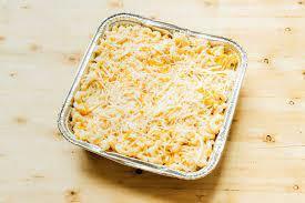 macaroni and cheese in an aluminum pan on a wood surface