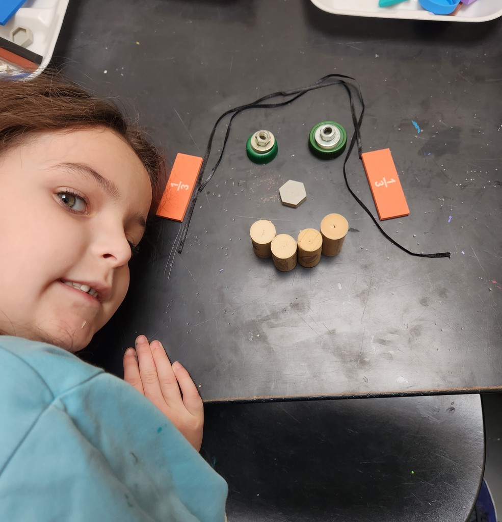 kindergarten student shows her face made of recycled materials