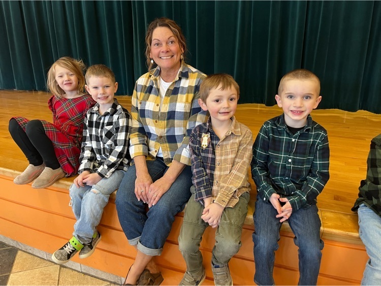 all wearing flannel, students pose with a staff member