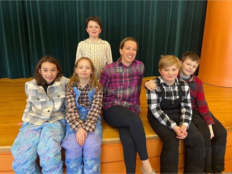 all wearing flannel, students pose with a staff member