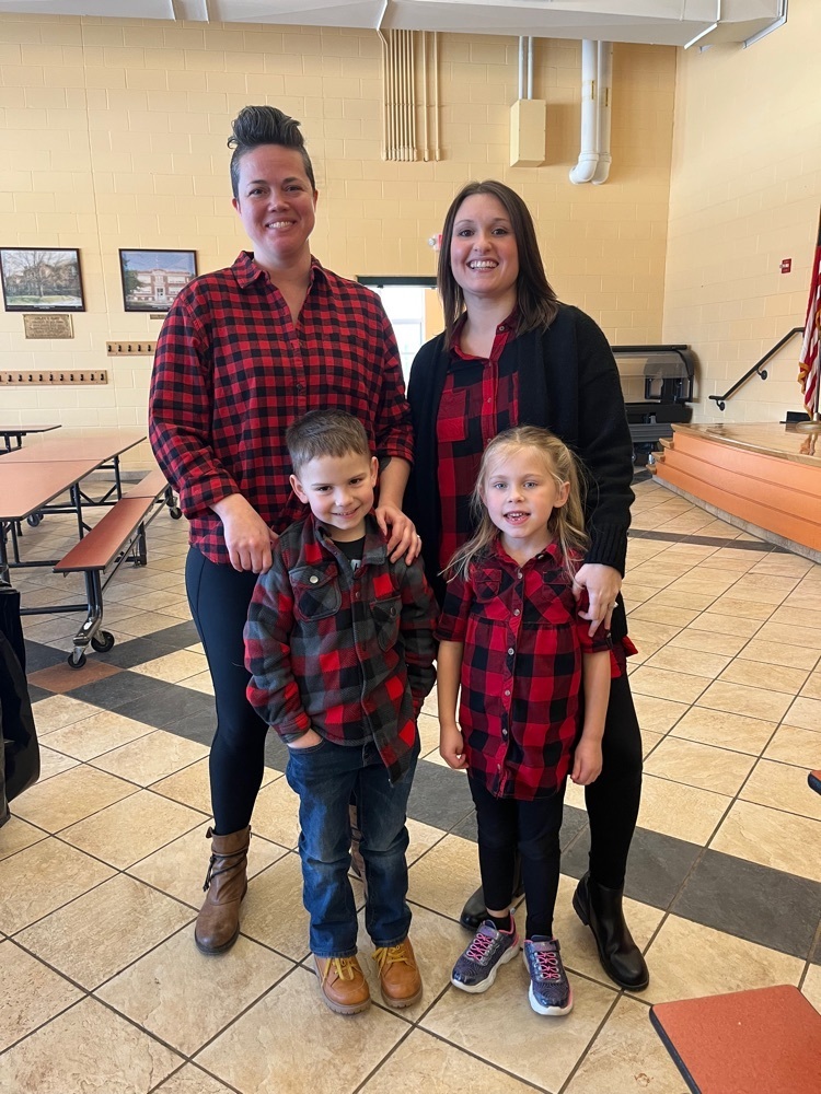 all wearing flannel, students pose with staff members