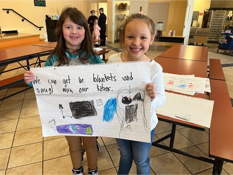first graders holding up a poster with tips for keeping warm