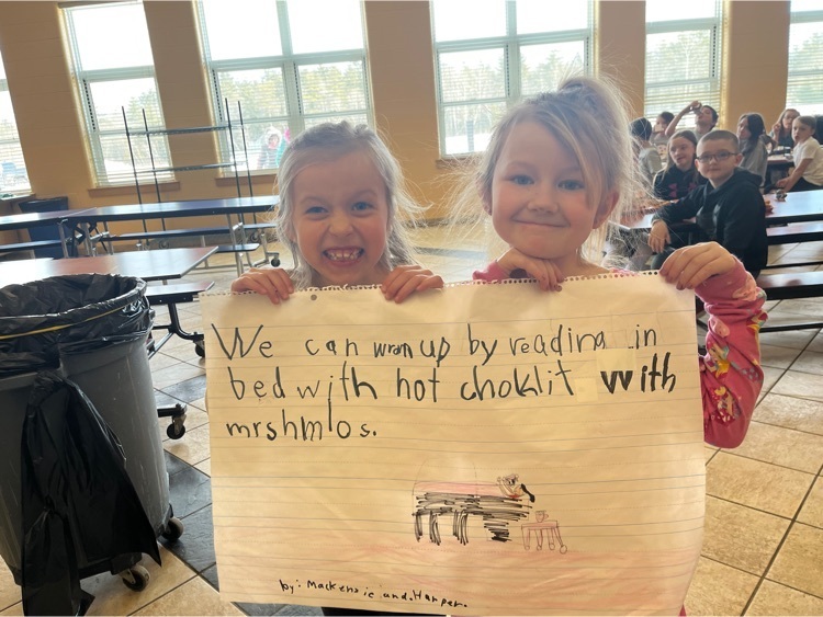 first graders holding up a poster with tips for keeping warm