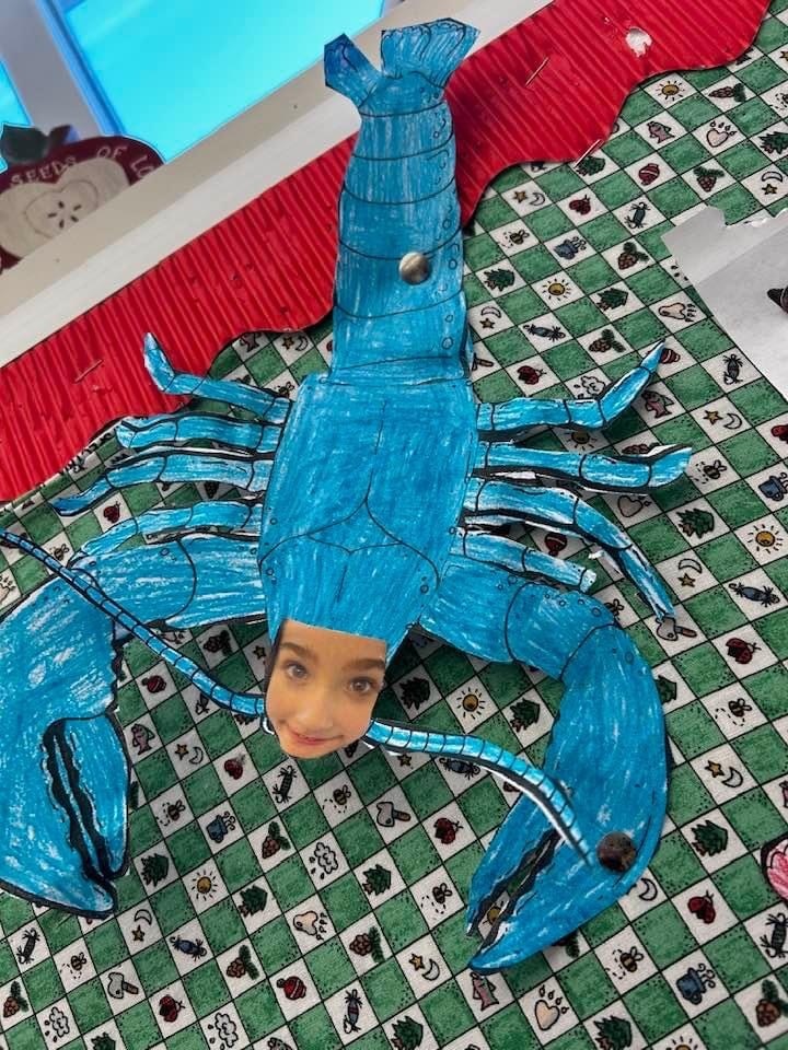 realistic lobster made of paper with students face glued on
