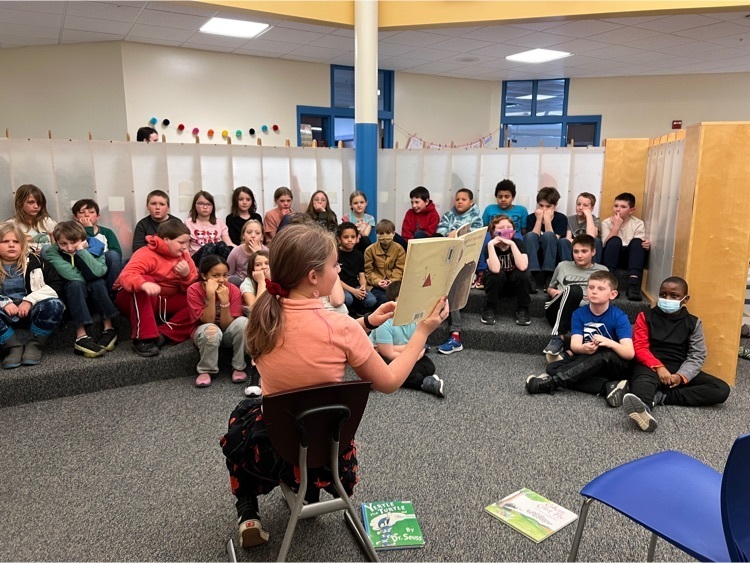 student reading to a group of younger students